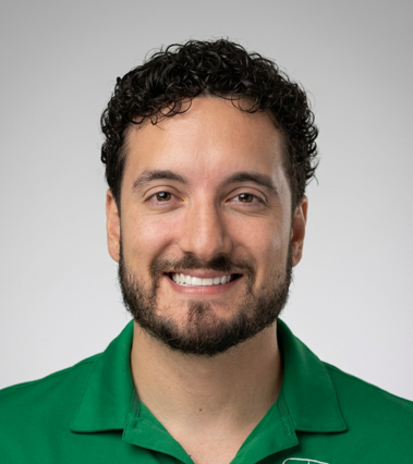 Smiling man in a green polo shirt against a light gray background
