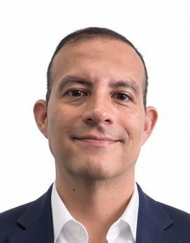 Headshot of a man in a navy blazer and white shirt, smiling against a plain white background