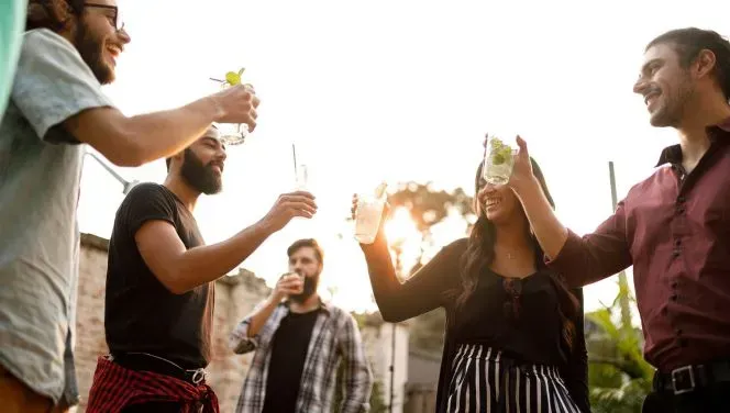 A group of friends raise their glasses of THC infused weed mocktails to say 