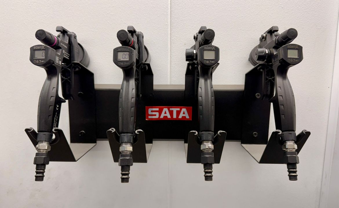 Four black wall-mounted tool holders with red SATA label on a rack