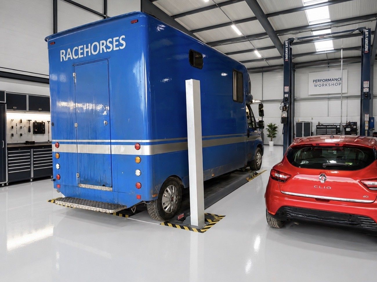Blue RaceMorse trailer in a garage beside a red car
