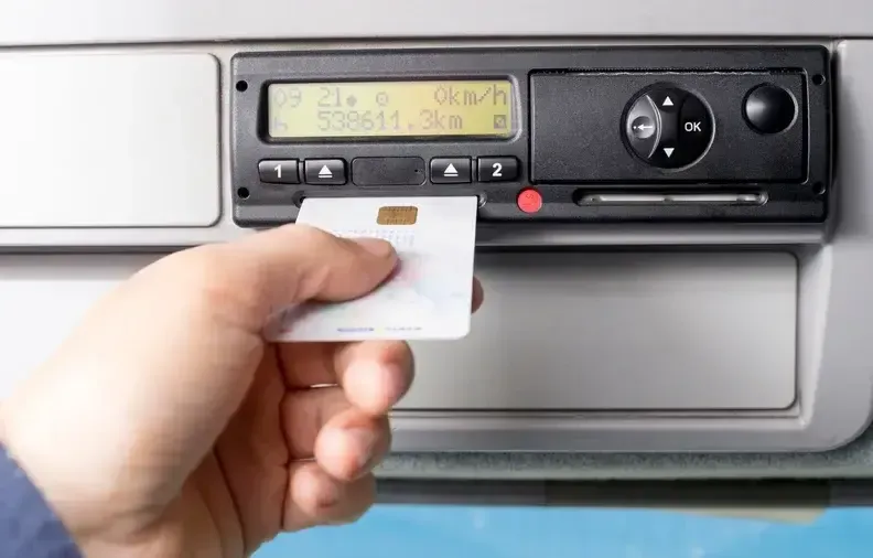 Hand inserting a white card into a car dashboard stereo card slot