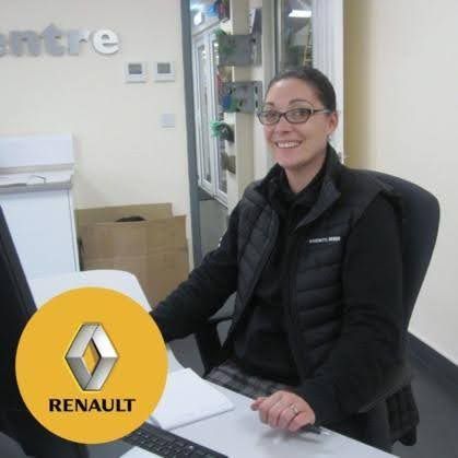 Smiling employee seated at a desk in a Renault office, with the Renault logo overlayed in the corner