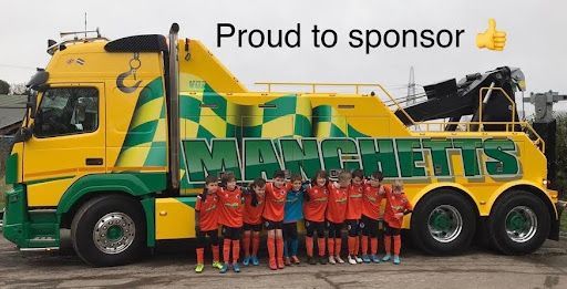 Manchetts sponsored football team group posing in front of a yellow-green Manchetts lorry with “Proud to sponsor” text
