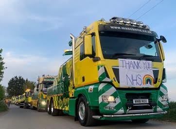 Yellow and green Manchetts truck convoy with a “THANK YOU NHS” sign on the front