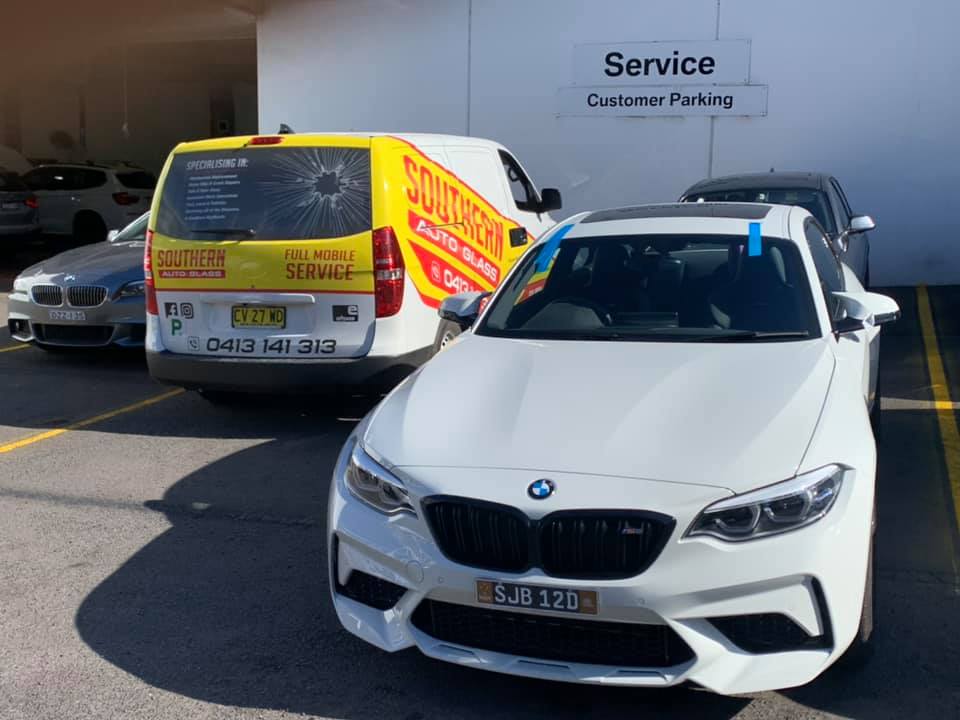 a white sedan and the Southern Auto Glass service truck