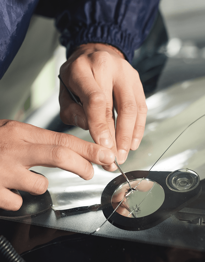 a man fixing a windscreen crack