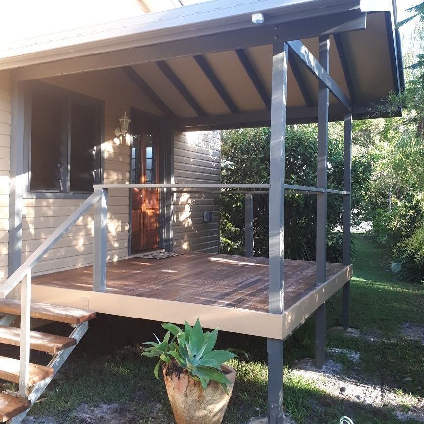 A Porch With Stairs And A Potted Plant On It — Pottsville Carpentry and Home Maintenance In Pottsville, NSW