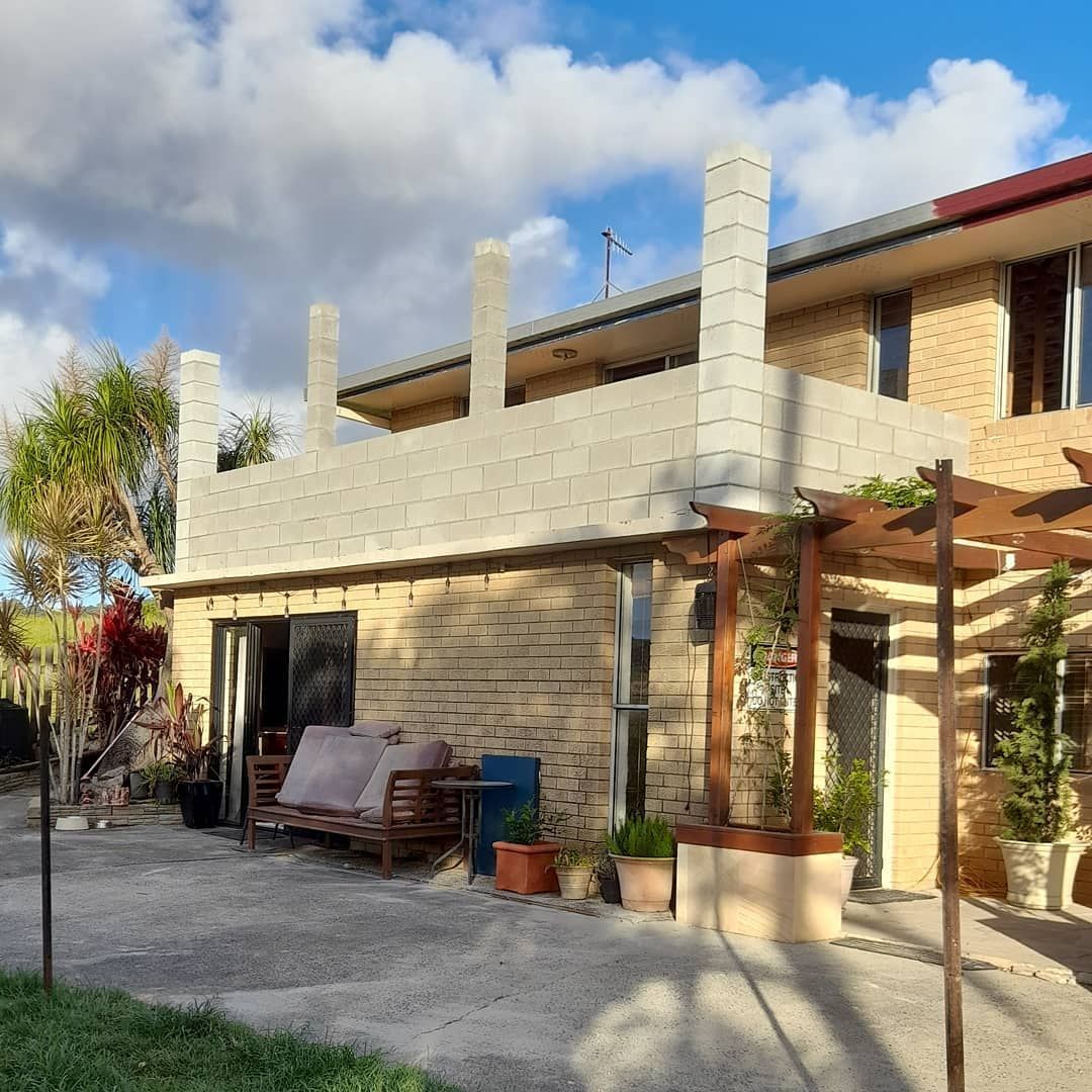 A Brick House With A Pergola In Front Of It — Pottsville Carpentry and Home Maintenance In Pottsville, NSW