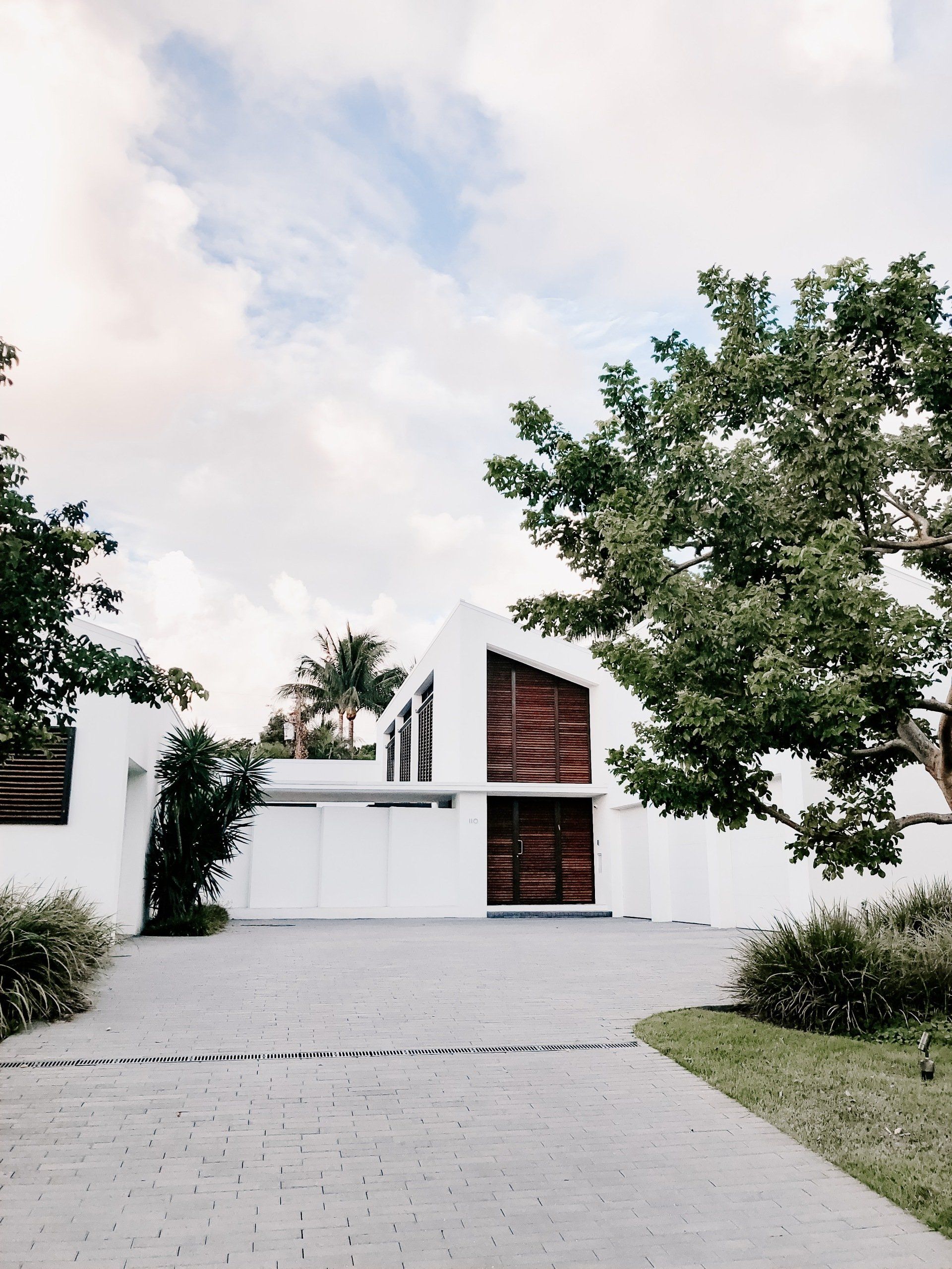 A White House with A Driveway and Trees in Front of It