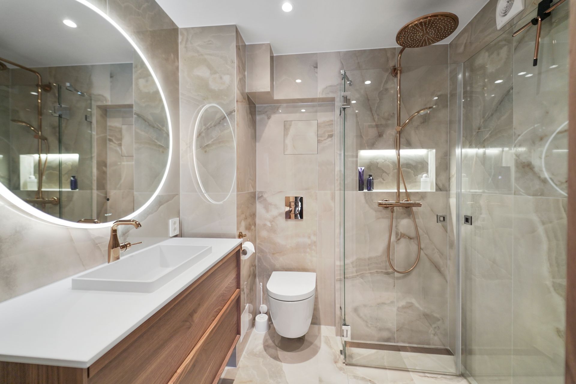 Moderne beige bad med dobbel vask, store speil, glassdusj og vegghengt toalett
