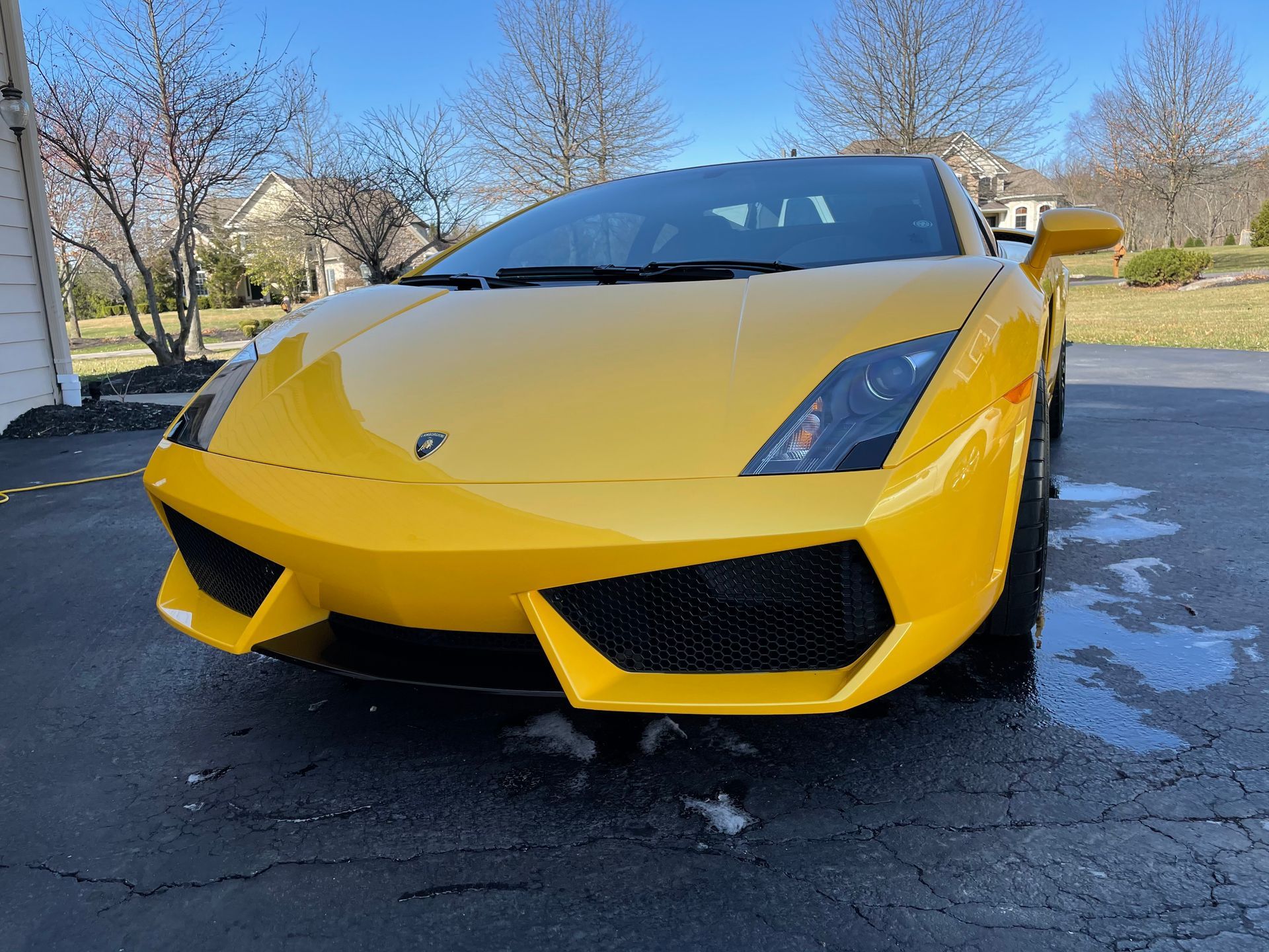 A yellow lamborghini gallardo is parked in a driveway.