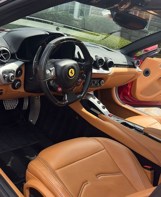 The interior of a ferrari sports car with brown leather seats