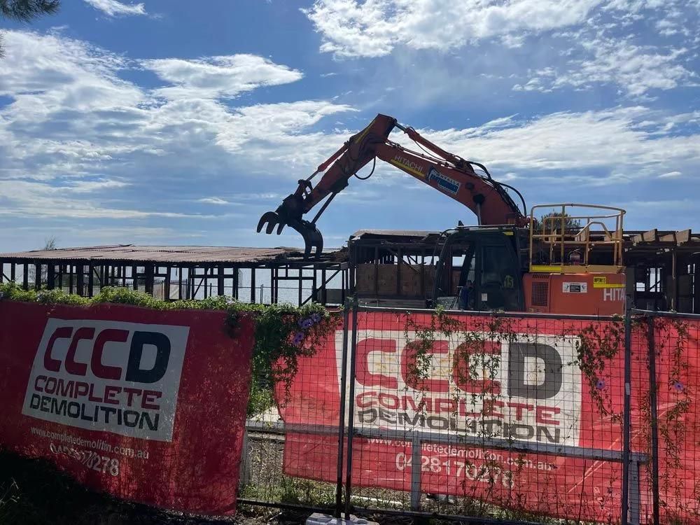 Two Men in Protective Suits Are Working on The Roof of A House — Central Coast Complete Demolition & Tree Service in Buff Point, NSW