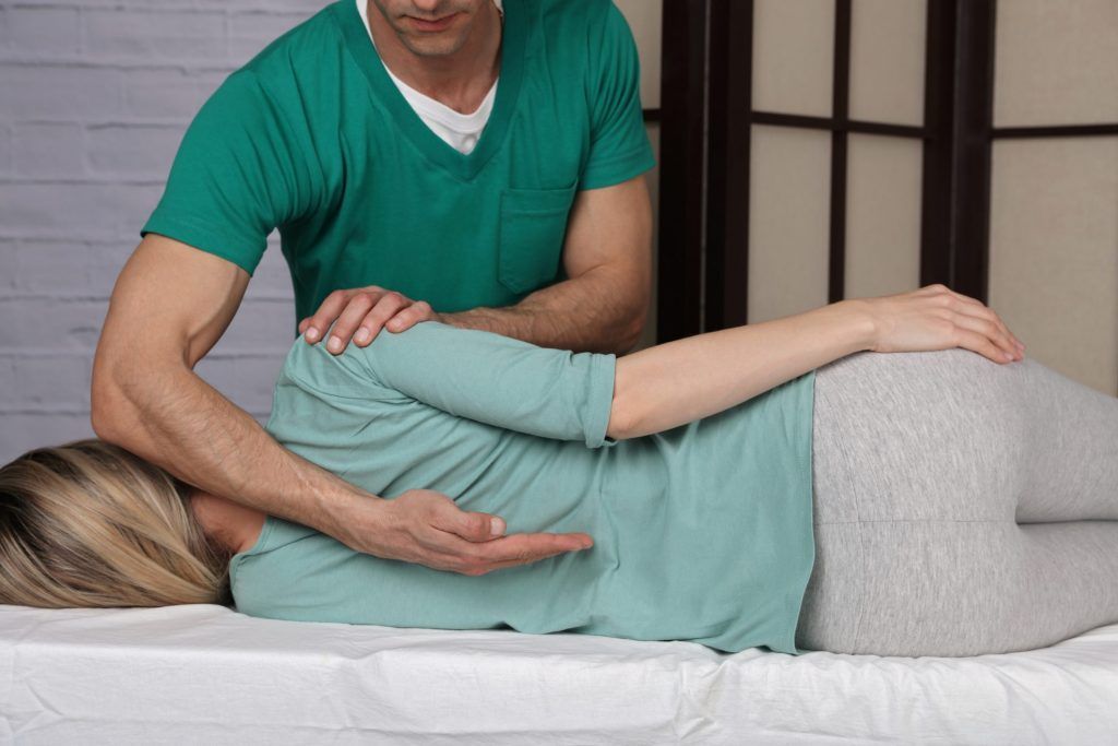 Un uomo sta facendo un massaggio a una donna su un letto.