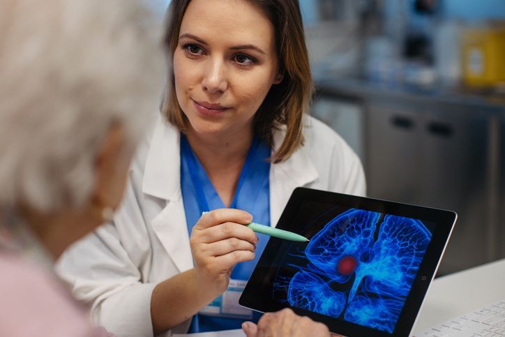 Un medico indica un tablet su cui è raffigurato un cervello.