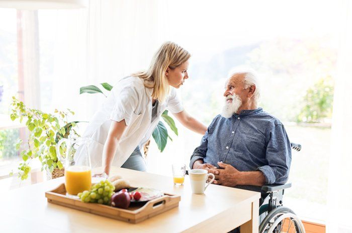 Young Female Health Visitor and a Senior Man — Austintown, OH — Moonlight Home Health Care A man receiving assisted home care services in Austintown, OH