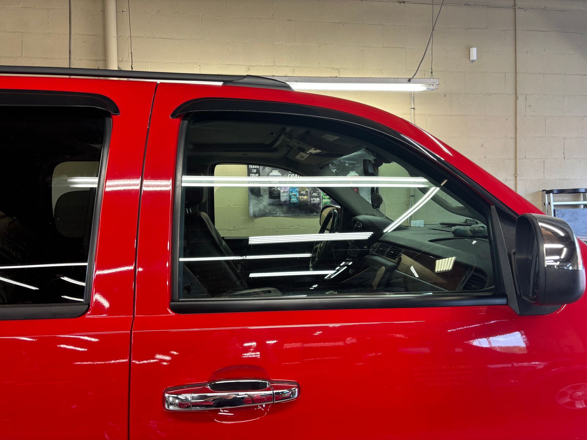 A red suv is parked in a garage with the door open.
