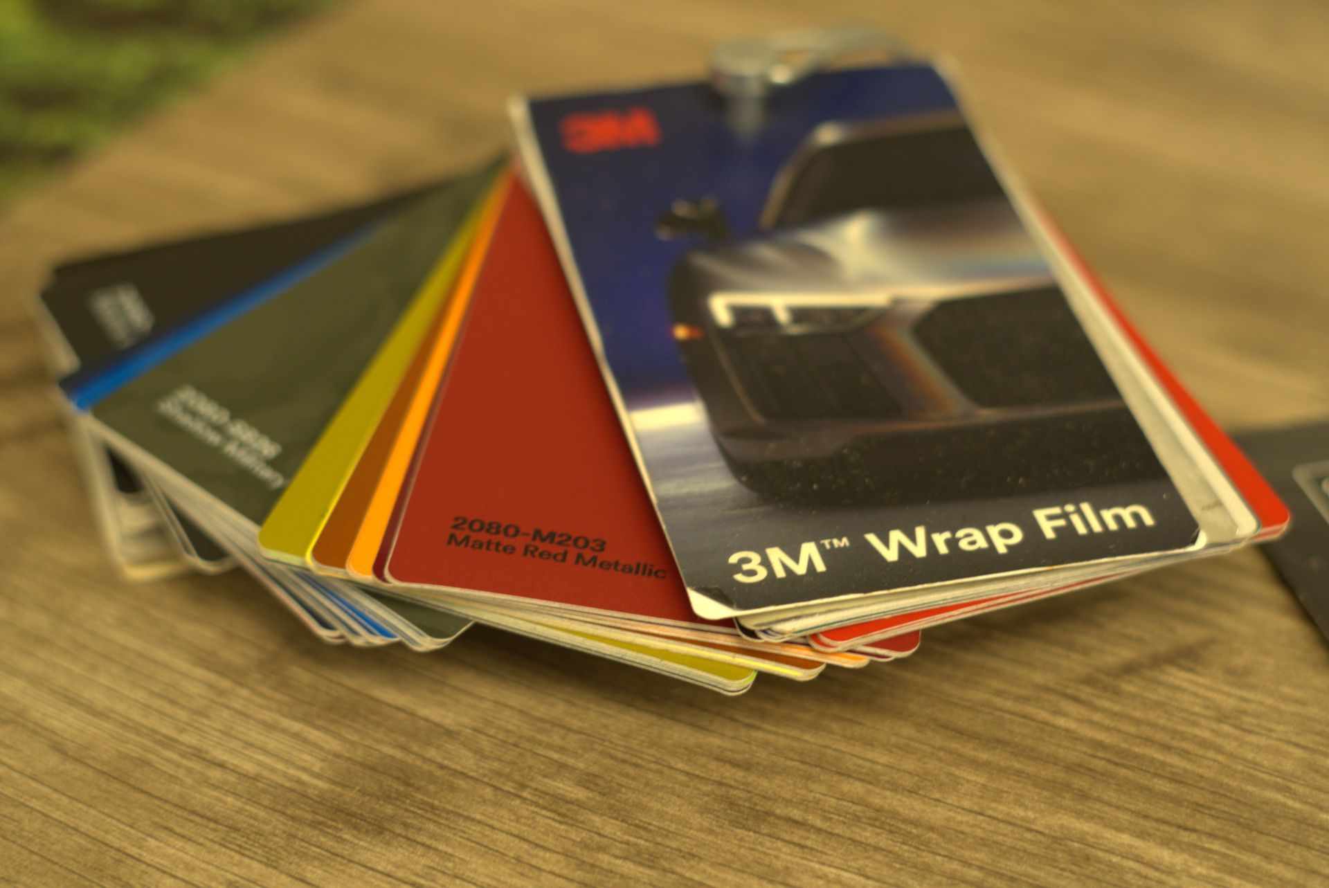 3M wrap film color swatches fanned out on a wooden table