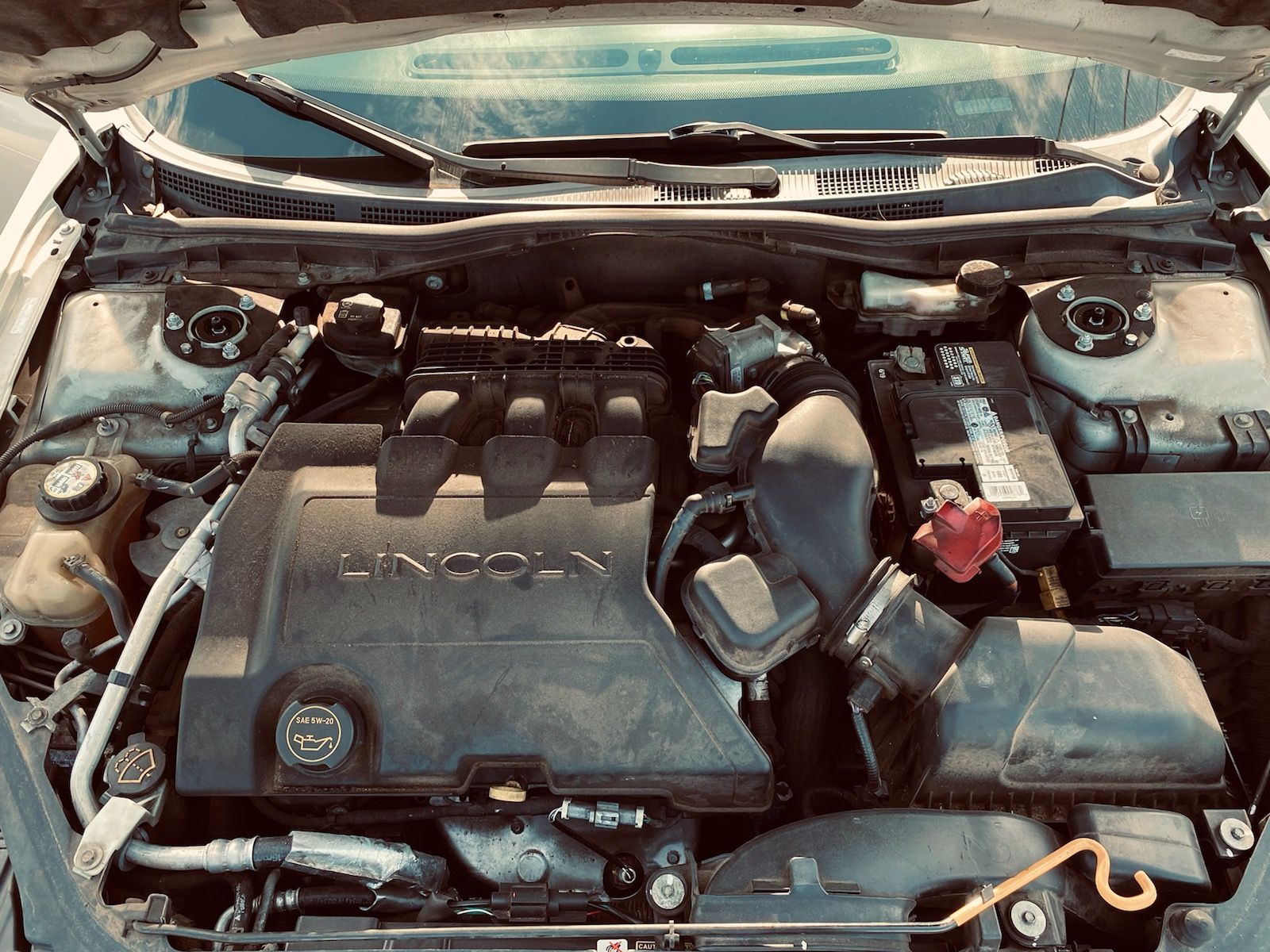 The engine of a lincoln car is shown with the hood up.