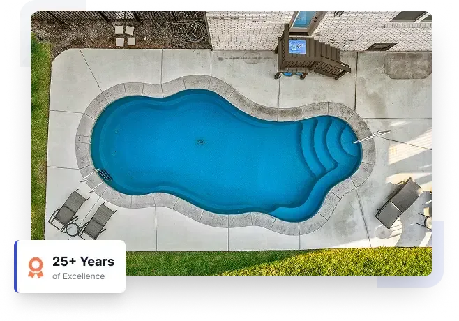 Top-down view of a blue in-ground pool with light stone patio and steps at one end