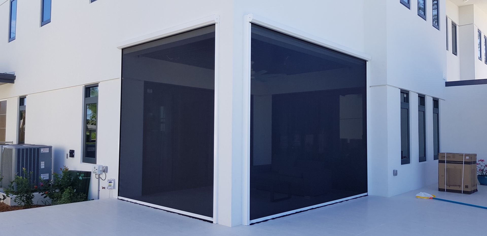 A white house with a black screen on the side of it.
