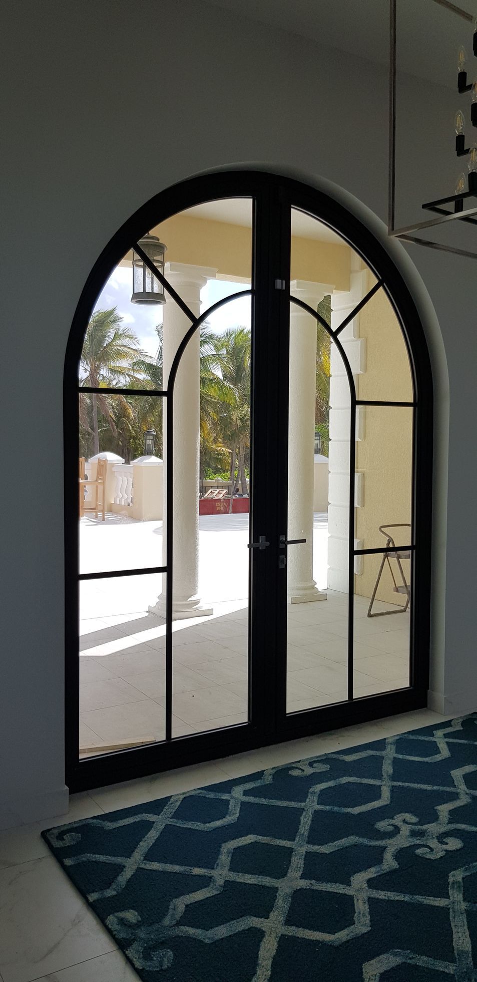 A pair of arched doors leading to a patio in a house.