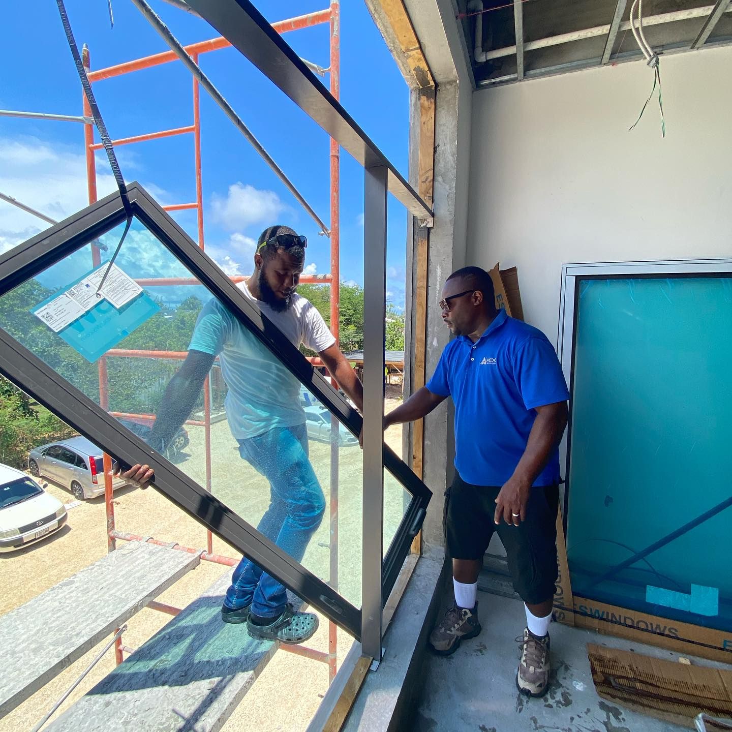 A man in a blue shirt is working on a window