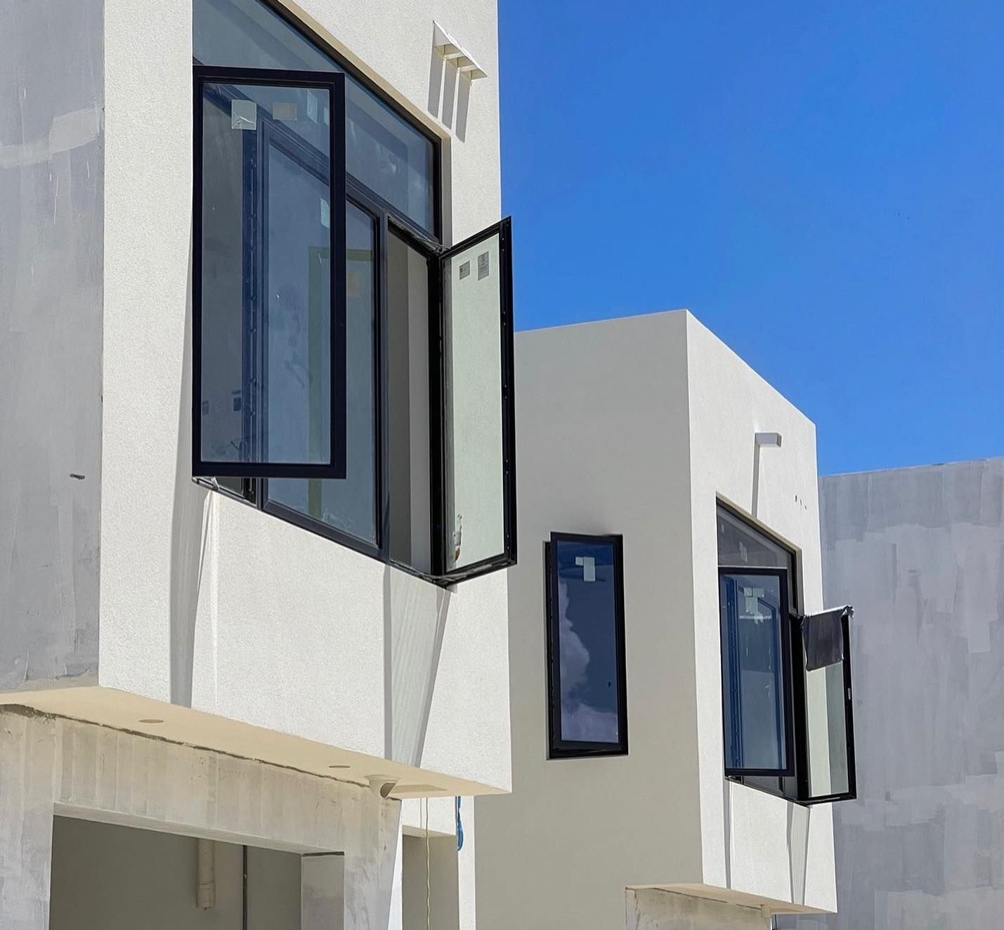 A white building with black windows and a blue sky in the background