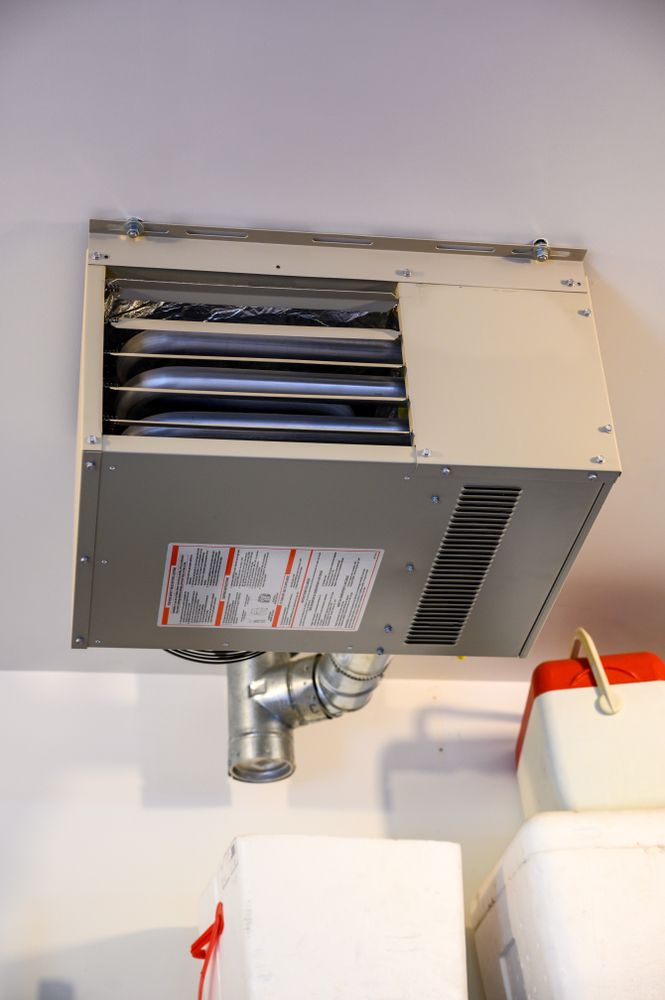 Ceiling-mounted metal HVAC vent and ductwork above white cabinets