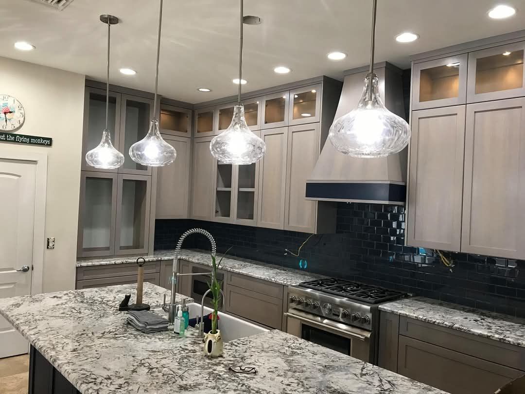 A long kitchen with stainless steel appliances and wooden floors.
