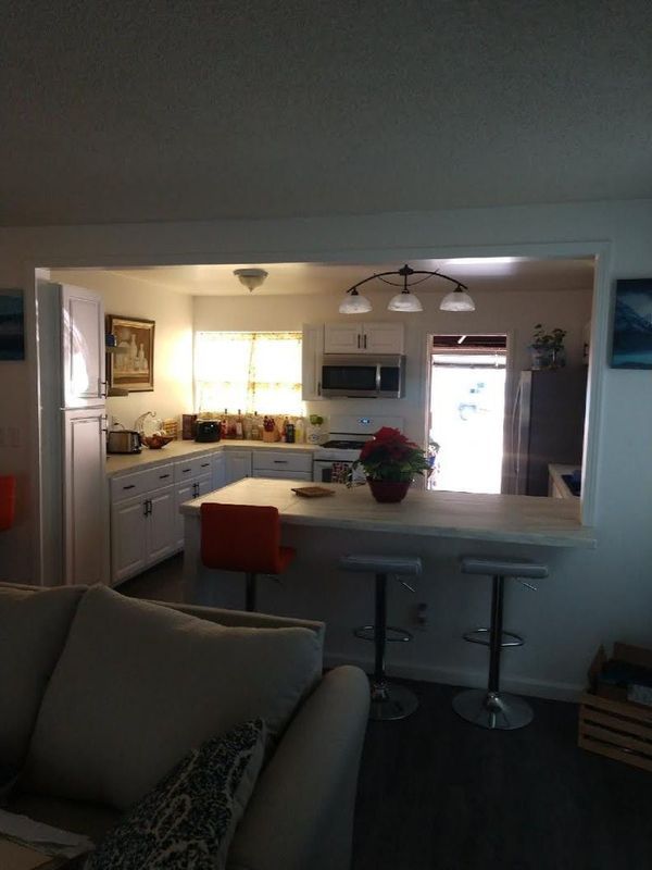 A living room with a couch and a kitchen in the background