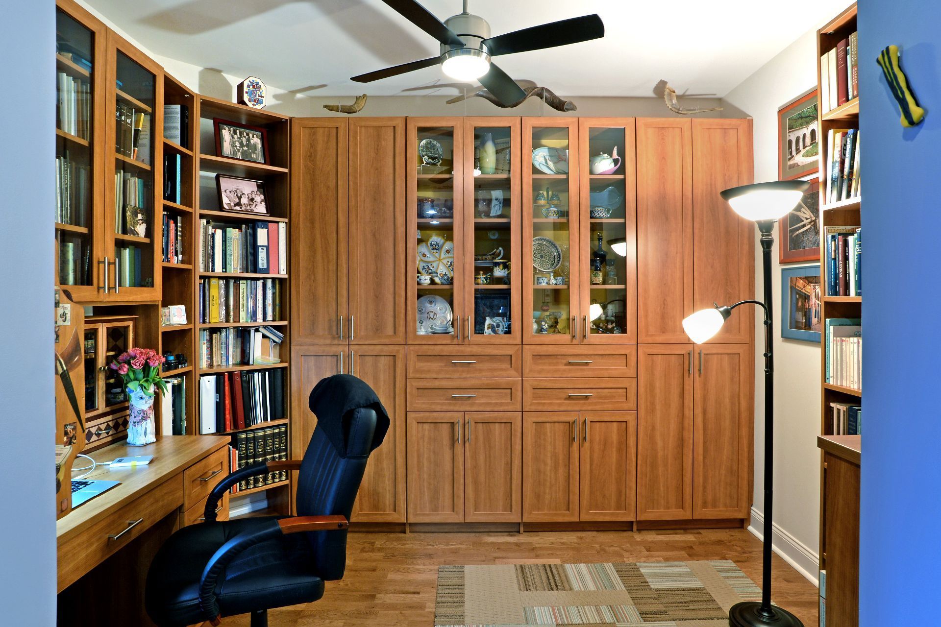 Walk-in closet with wooden shelves, clothes, luggage, and shoes.