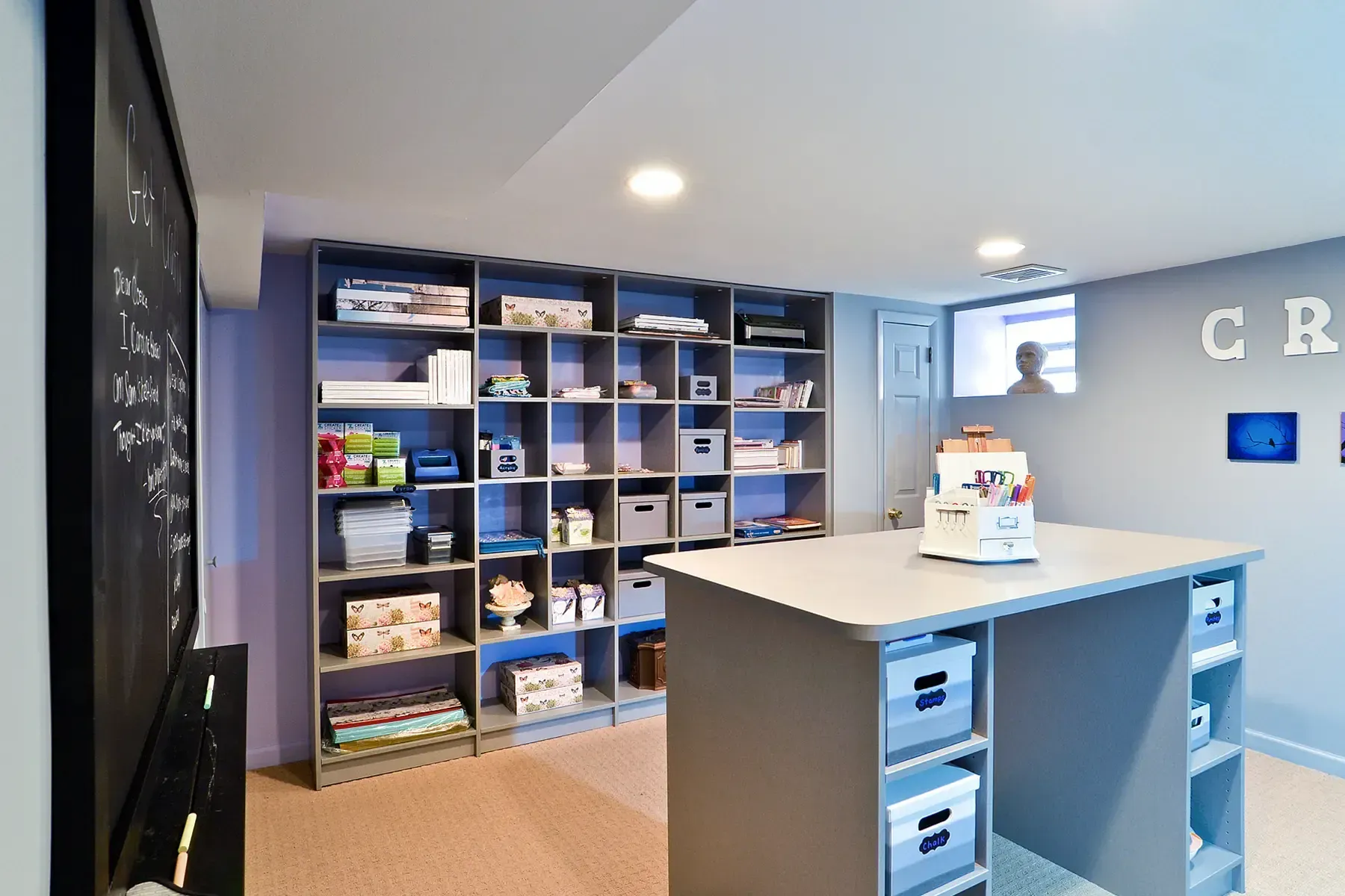 Walk-in closet with wooden shelves, clothes, luggage, and shoes.