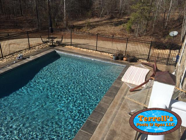 A large swimming pool with a sign that says terrell 's pool & spa llc