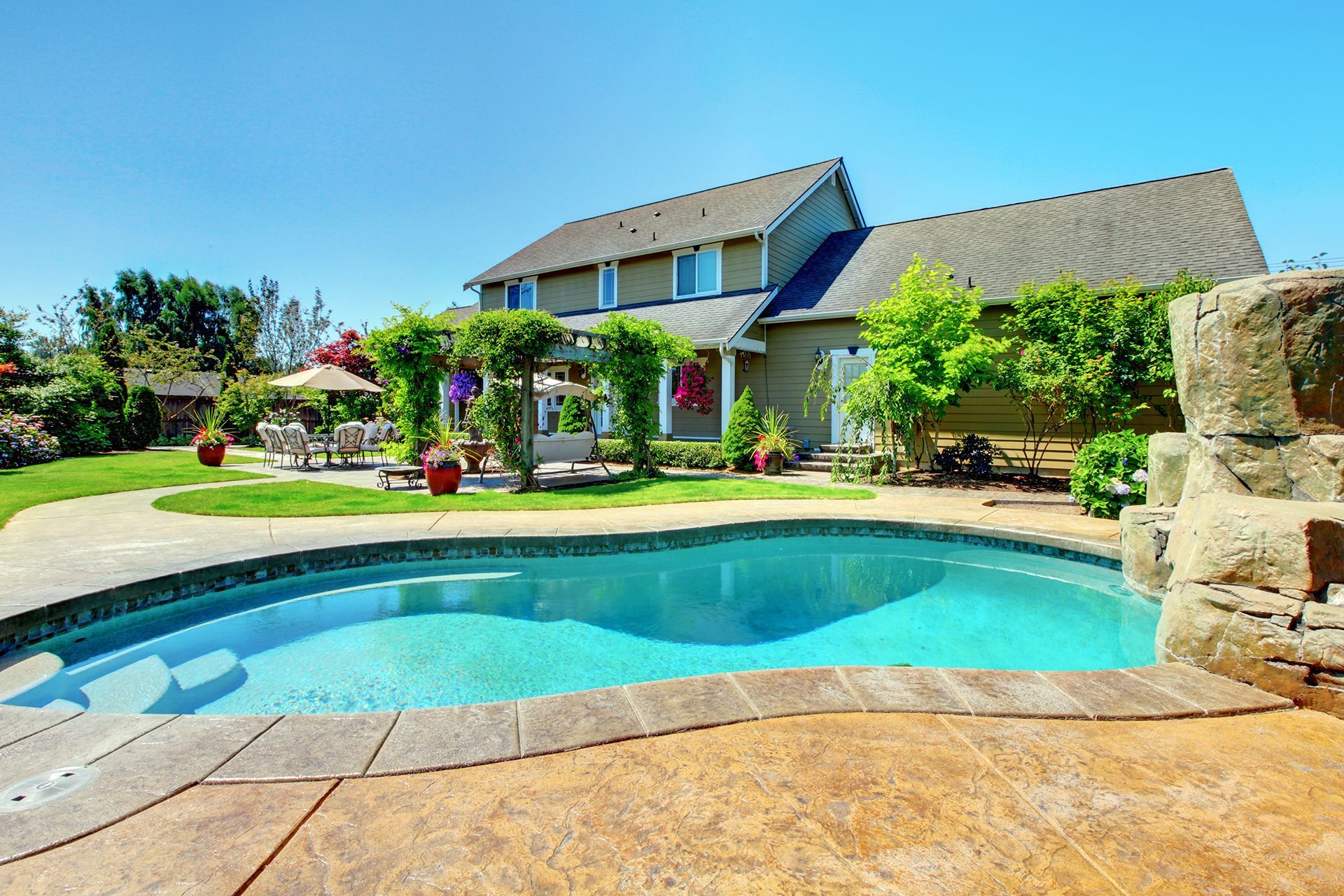 A large house with a large swimming pool in front of it.