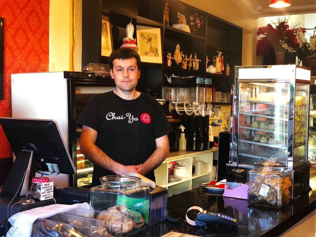 A man wearing a black shirt with the word chai on it