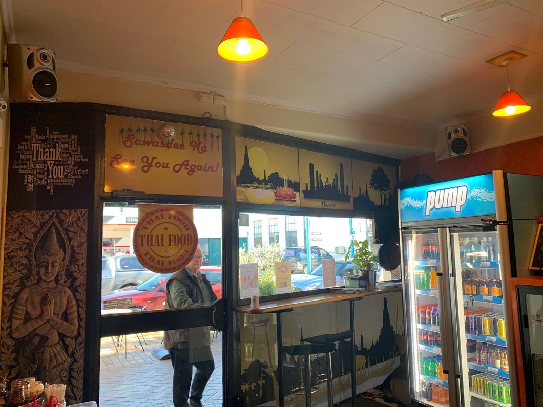 A man is standing in front of a window in a restaurant.