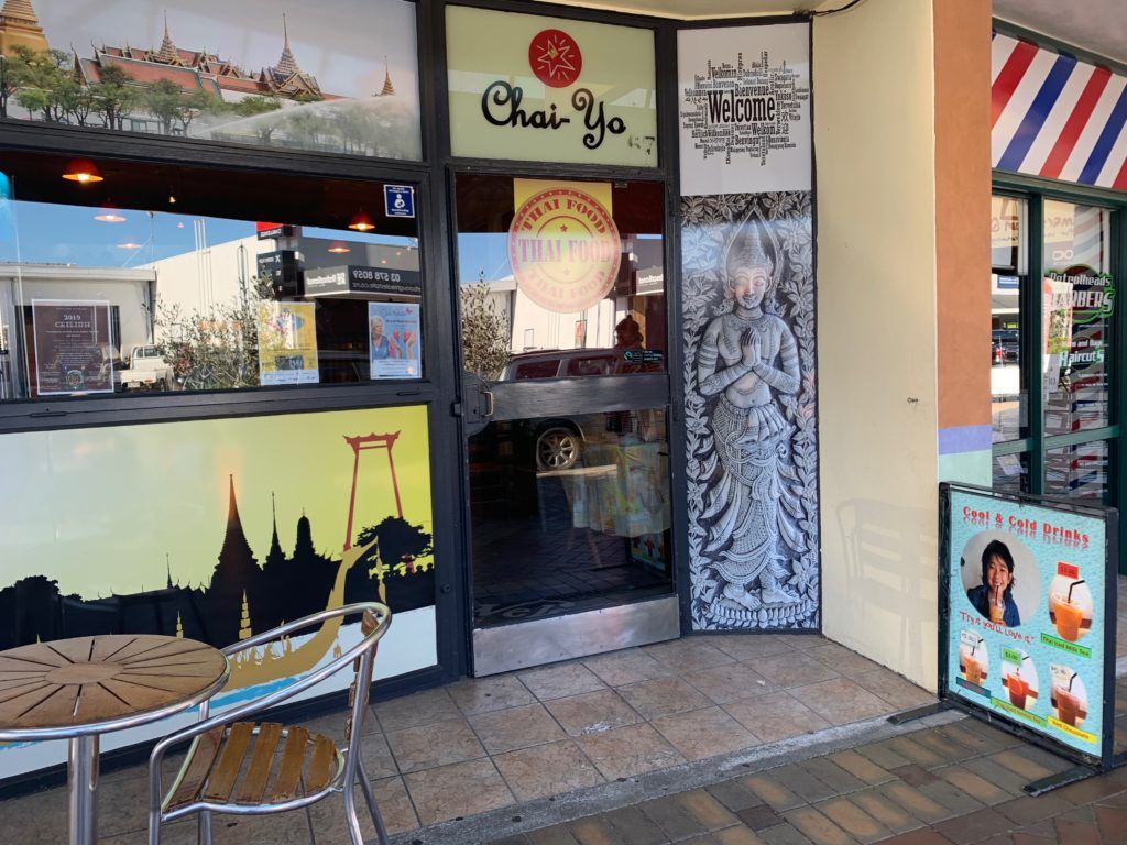 A restaurant with a table and chairs in front of it.