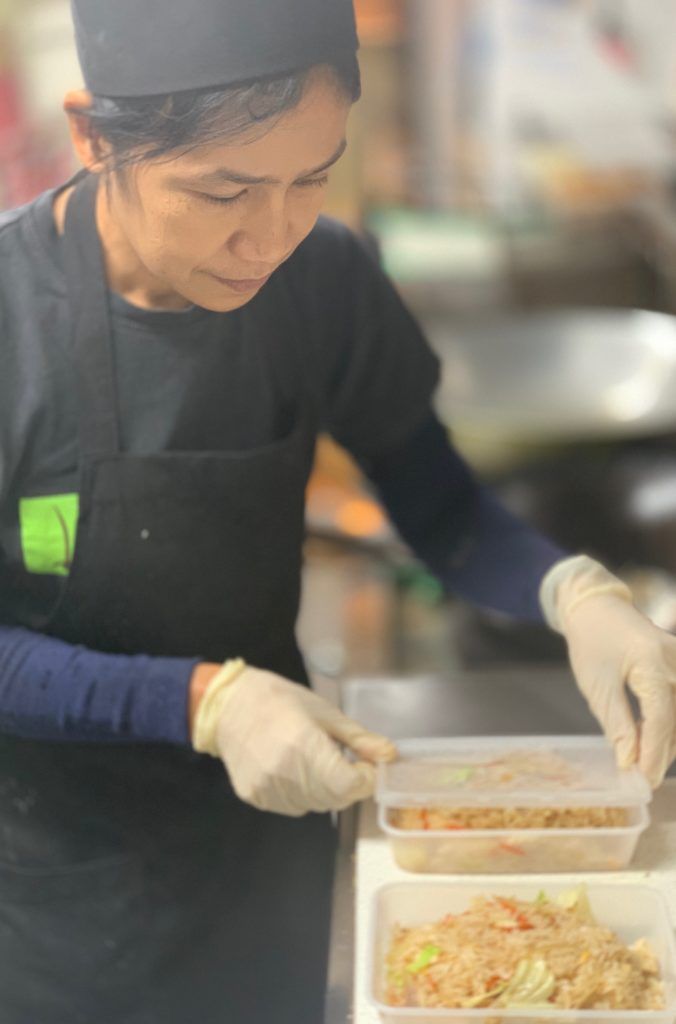 A woman is preparing food in a kitchen.