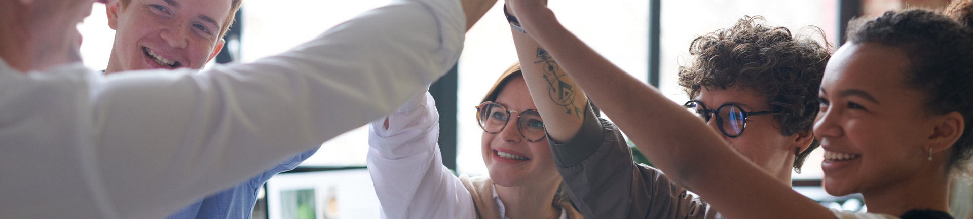 Team members giving a celebratory high-five in a bright office room