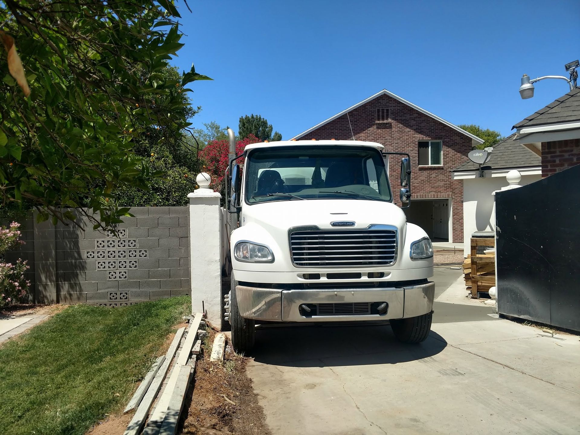 Freshly finished broom-textured residential driveway pour in Mesa, AZ suburban setting, warm afternoon light