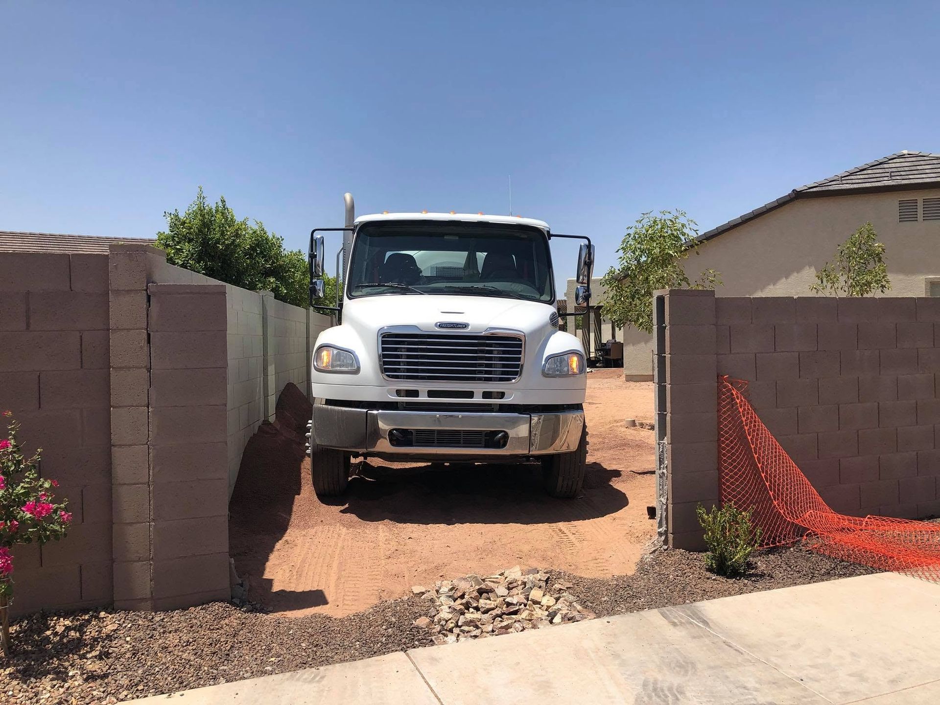 Backyard patio slab pour in progress with concrete chute extended, desert landscaping, Gilbert, AZ