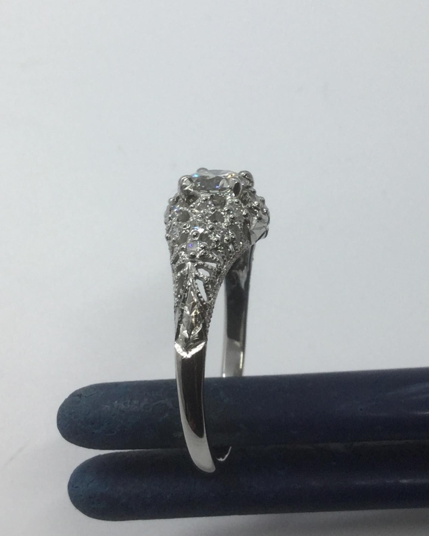A diamond ring is sitting on a blue cloth