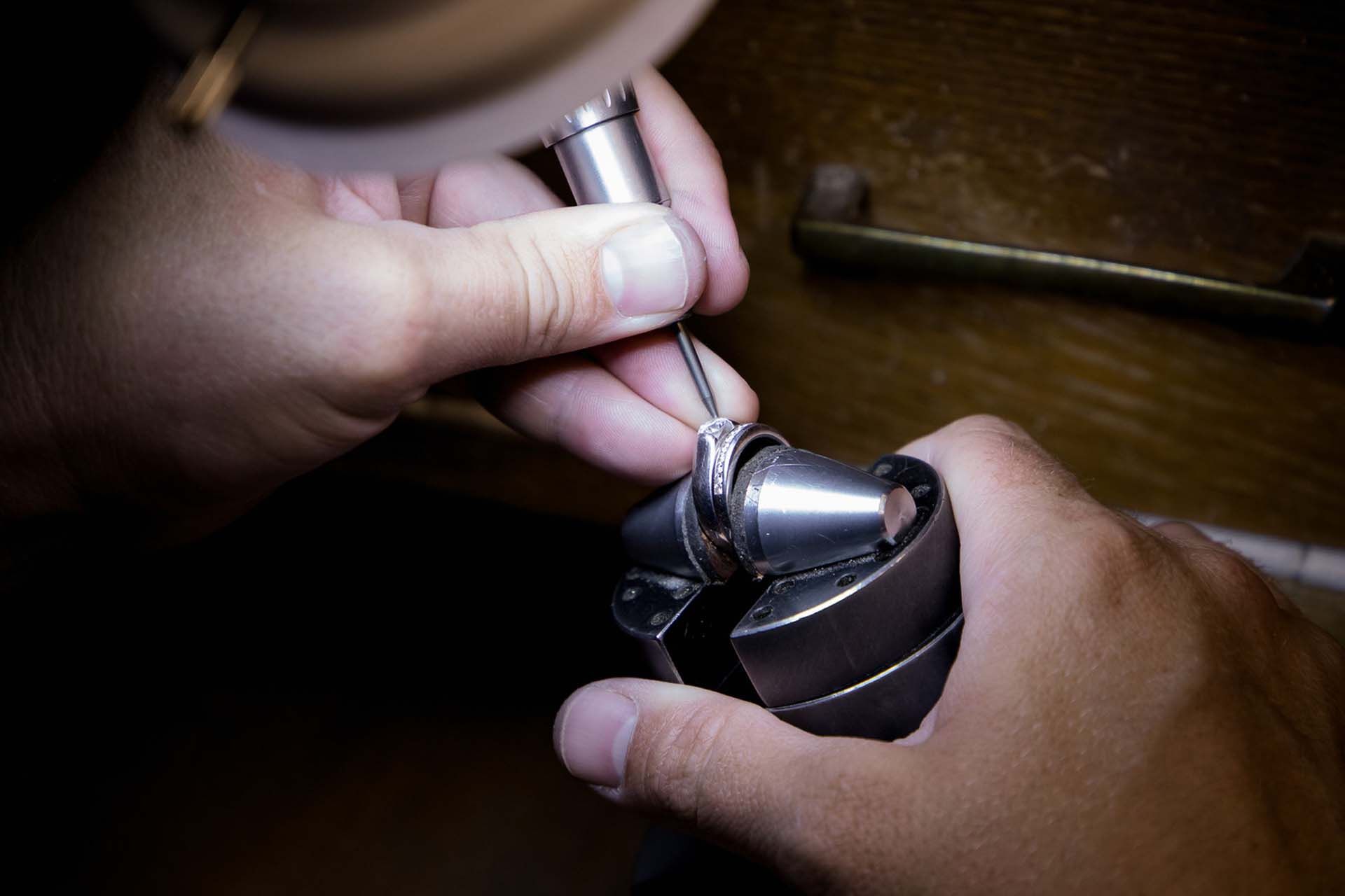 A person is working on a piece of metal with a tool.