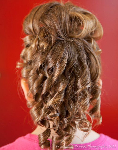 Back view of an elegant curly updo hairstyle against a red background