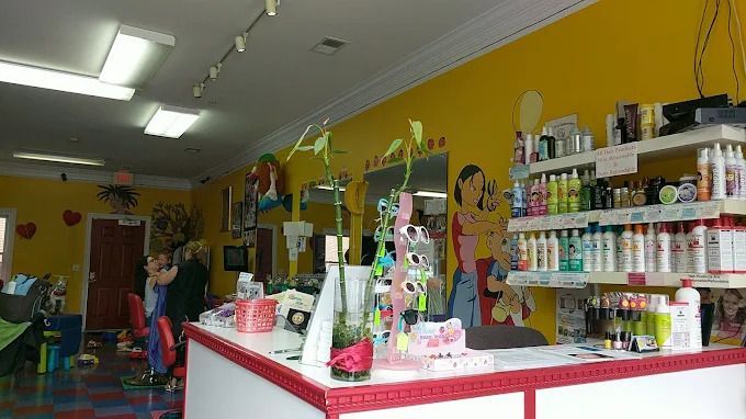 Three staff members standing in a colorful playroom with toys and wall decorations