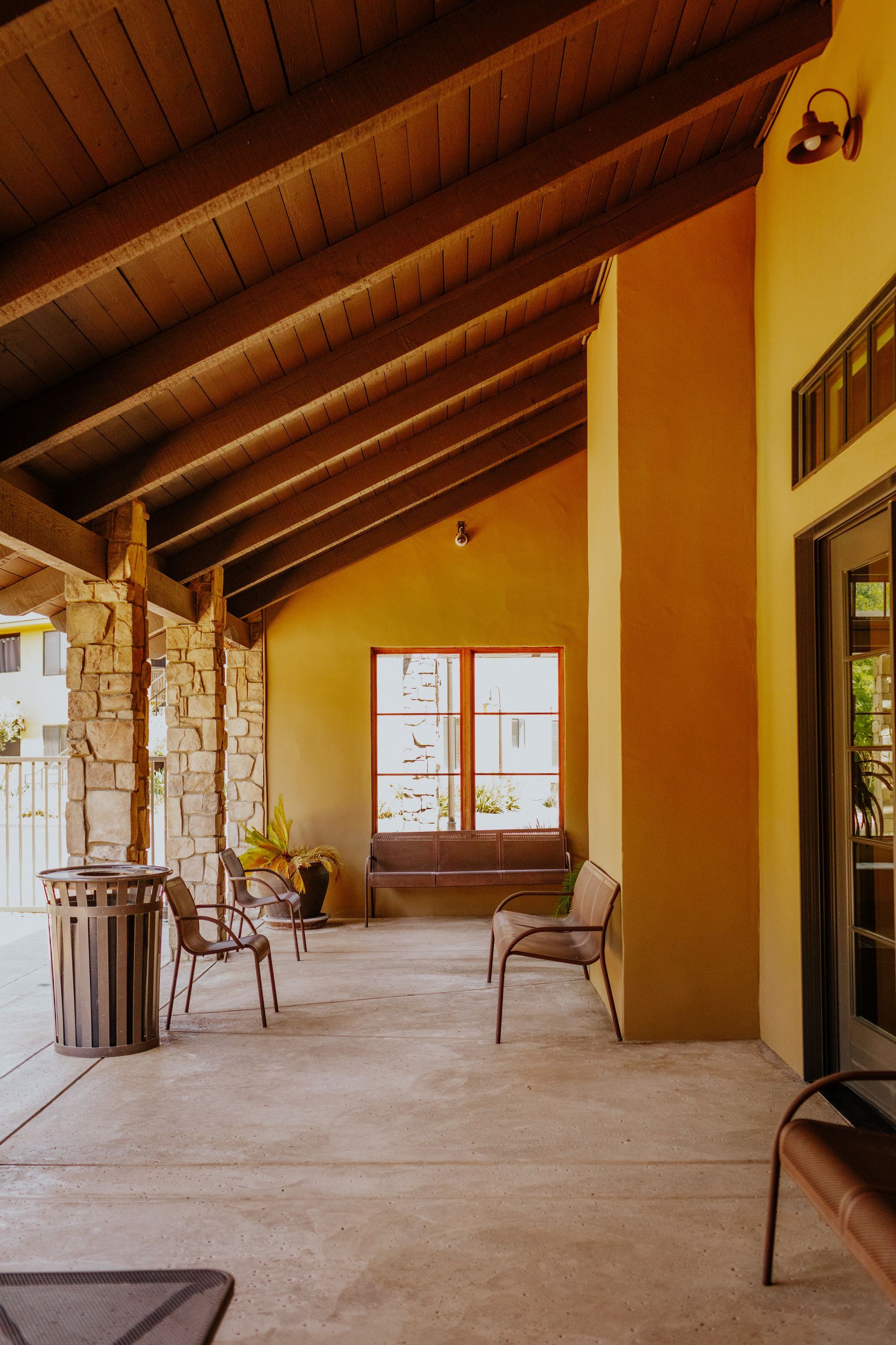 A patio with a wooden ceiling and a table and chairs
