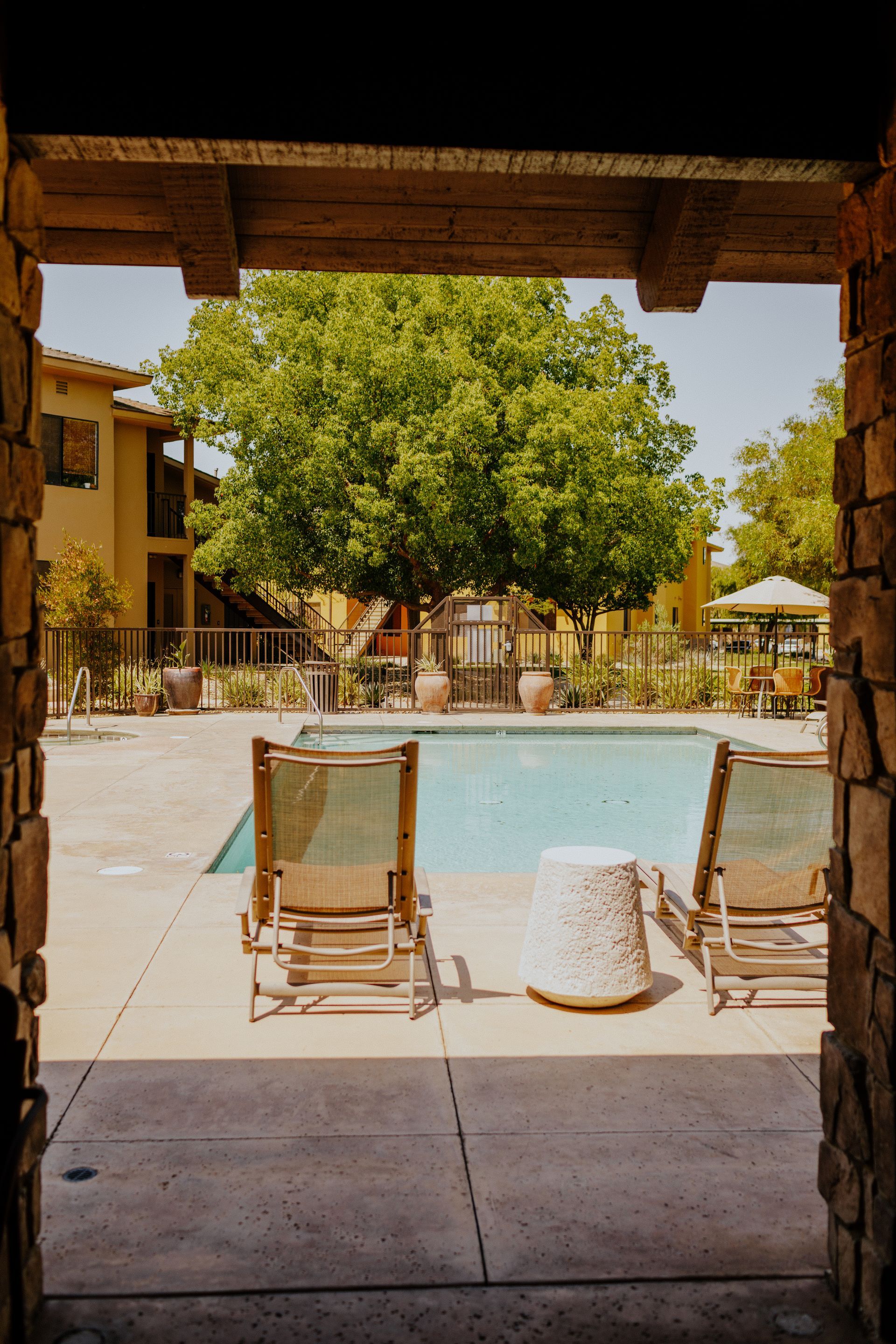 A view of a swimming pool through a stone archway.