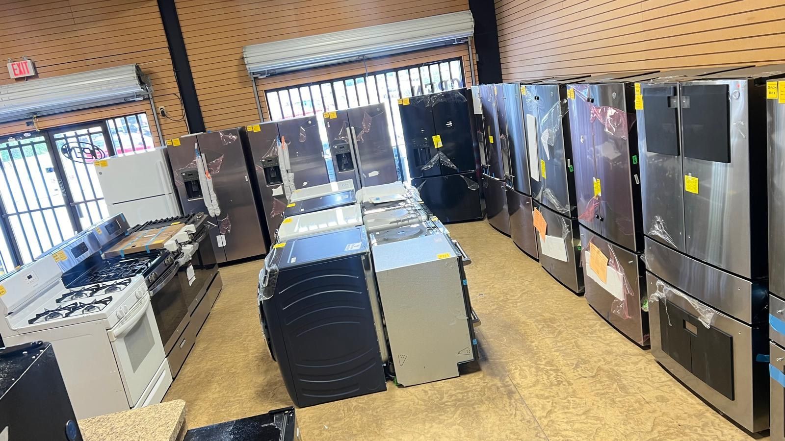 A store filled with lots of appliances including refrigerators , washers and dryers.